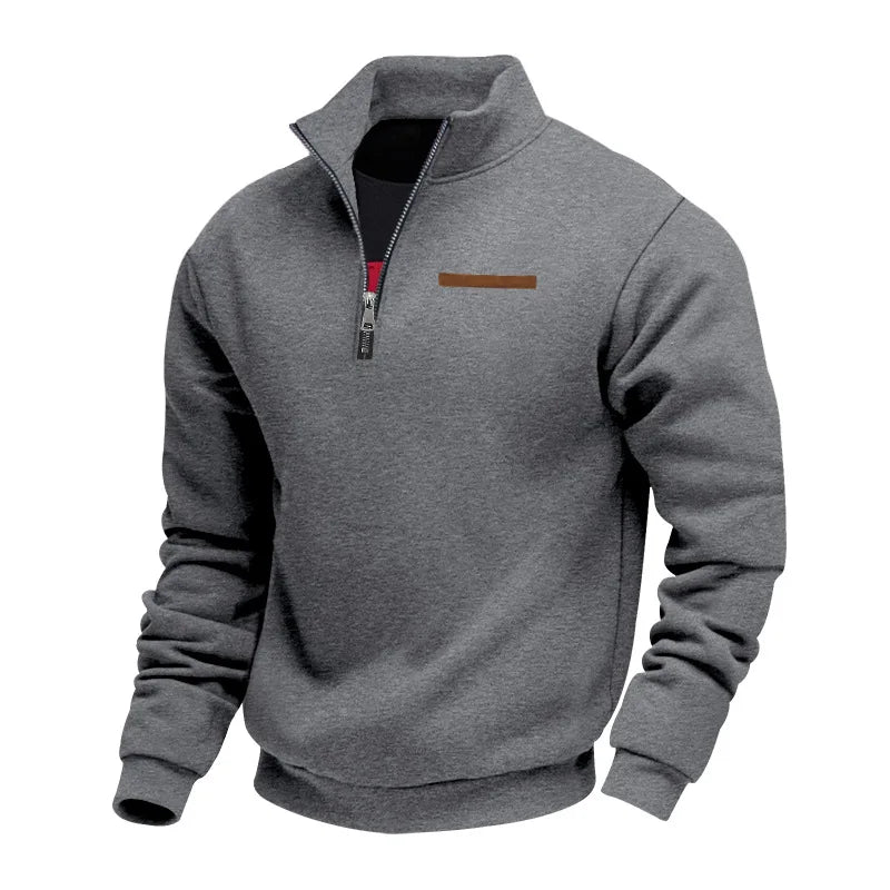 Dark gray half-zip fleece sweatshirt with a stand collar, ribbed cuffs, and chest accent detail on a white background.