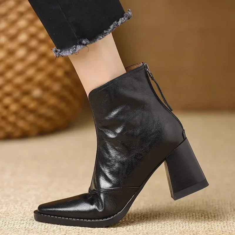 Black square-toe ankle boots in textured leather with a notched front collar and a sturdy, tall block heel.