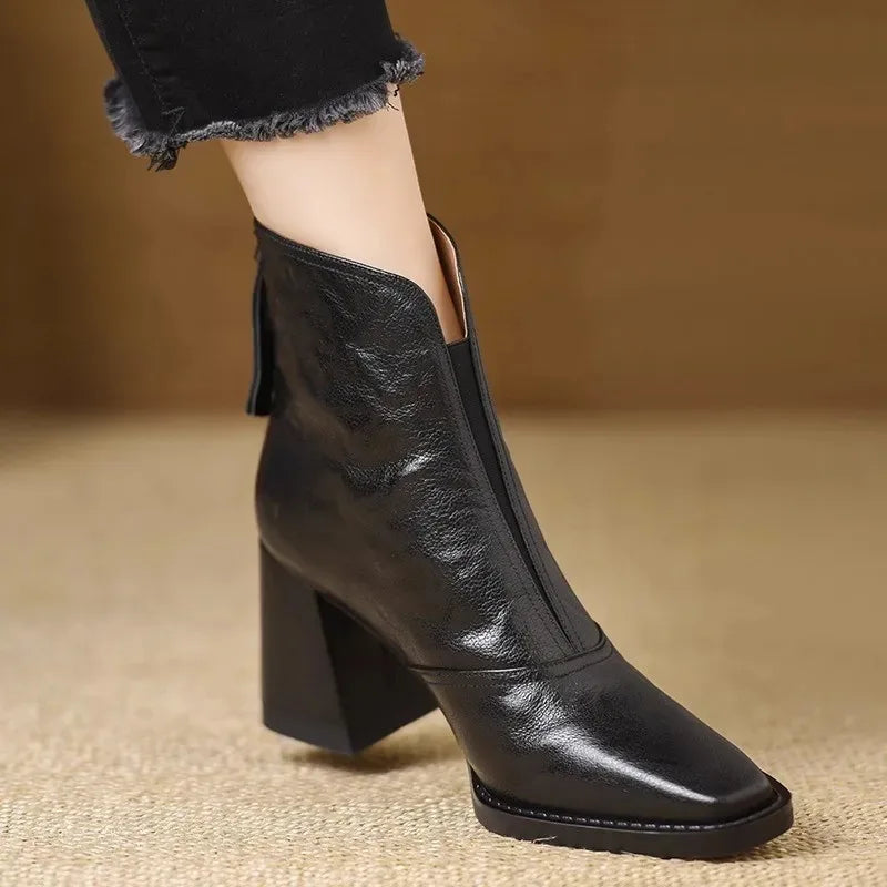 Black square-toe ankle boots in textured leather featuring a notched front collar and a sturdy, tall block heel.