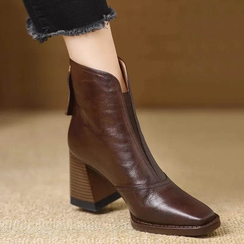 Dark brown square toe ankle boots with a notched front collar, side zip, and a tall, stacked block heel.