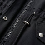 Black cotton blend utility jacket featuring a zip front, drawstring waist with metal toggles, and snap-button pockets.