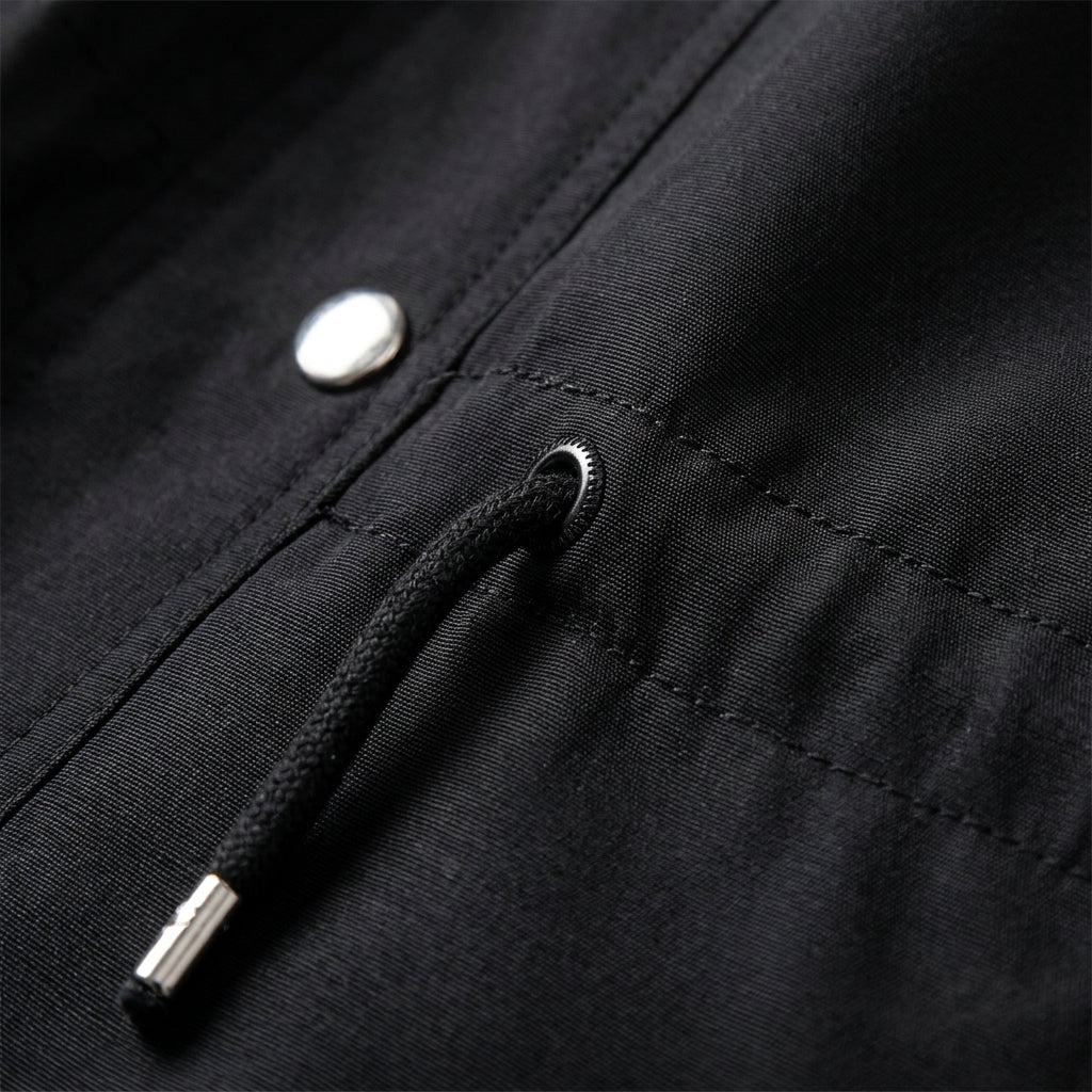 Black cotton blend utility jacket featuring a drawstring waist, silver hardware, and durable fabric texture.