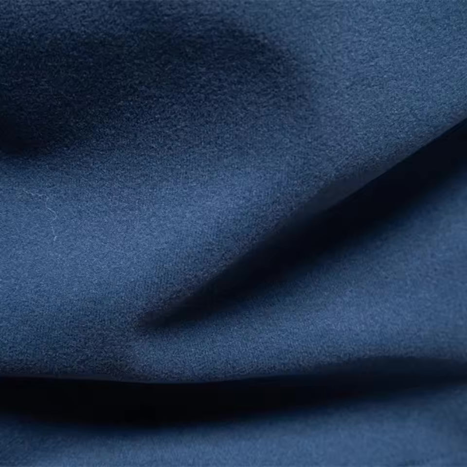 Close-up of a navy blue quarter zip sweater featuring a soft, brushed matte finish and smooth, napped fabric texture.