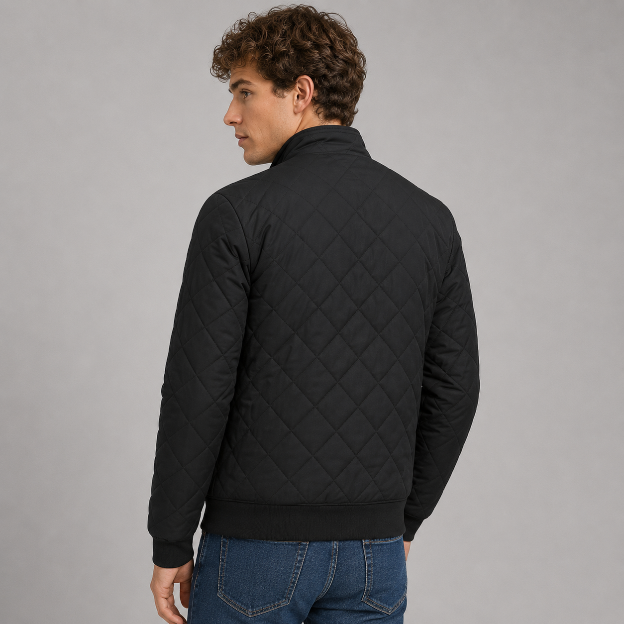 Black diamond-quilted zip-up jacket with a ribbed stand collar and relaxed fit, worn over blue jeans.