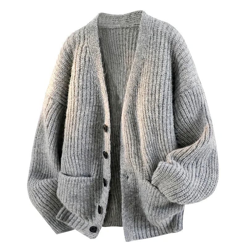 Grey oversized chunky knit cardigan with a fuzzy rib texture, V-neck, button front, and front patch pockets.