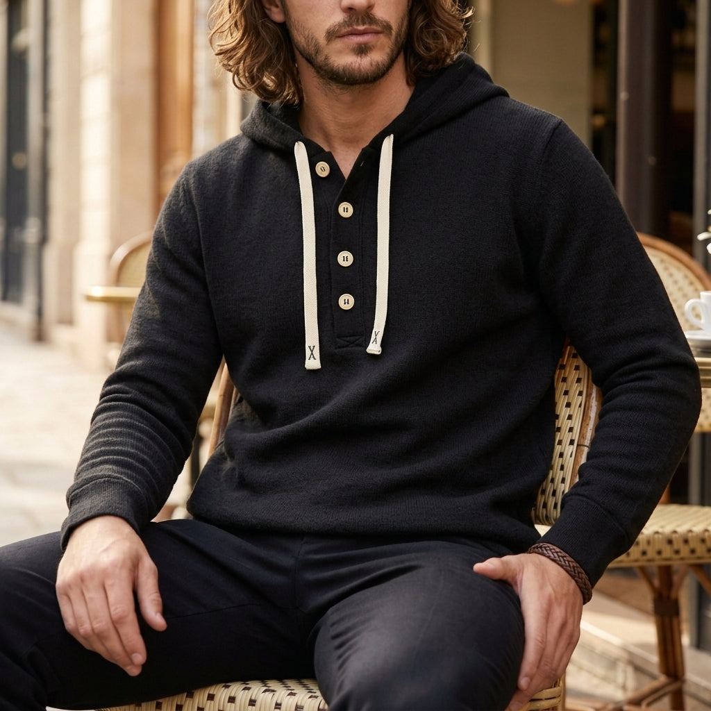 Black oversized henley hoodie worn by a male model, featuring a button placket, drawstrings, and kangaroo pocket.