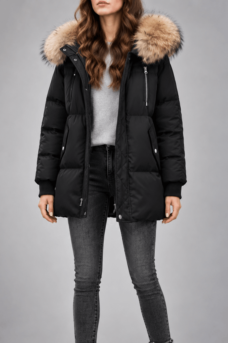 Black oversized puffer jacket with a plush-trim hood, quilted snap placket, and ribbed knit cuffs worn over grey jeans.