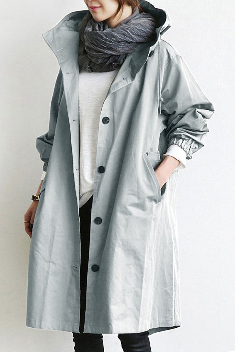 Oversized light gray hooded trench coat in lightweight fabric with a button-front placket and deep slant hip pockets.