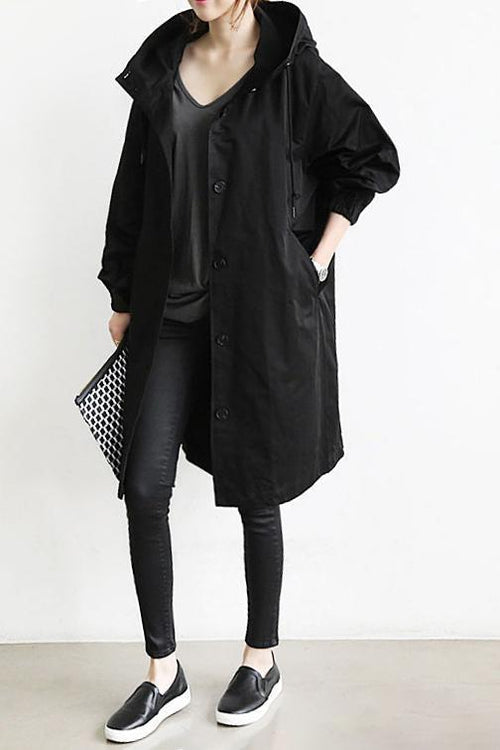 Oversized black hooded trench coat in lightweight fabric with a button-front placket and slant hip pockets.