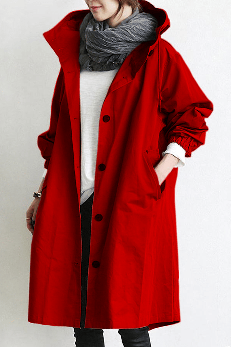 Oversized red hooded trench coat in lightweight fabric with a button-front placket, deep slant pockets, and elastic cuffs.