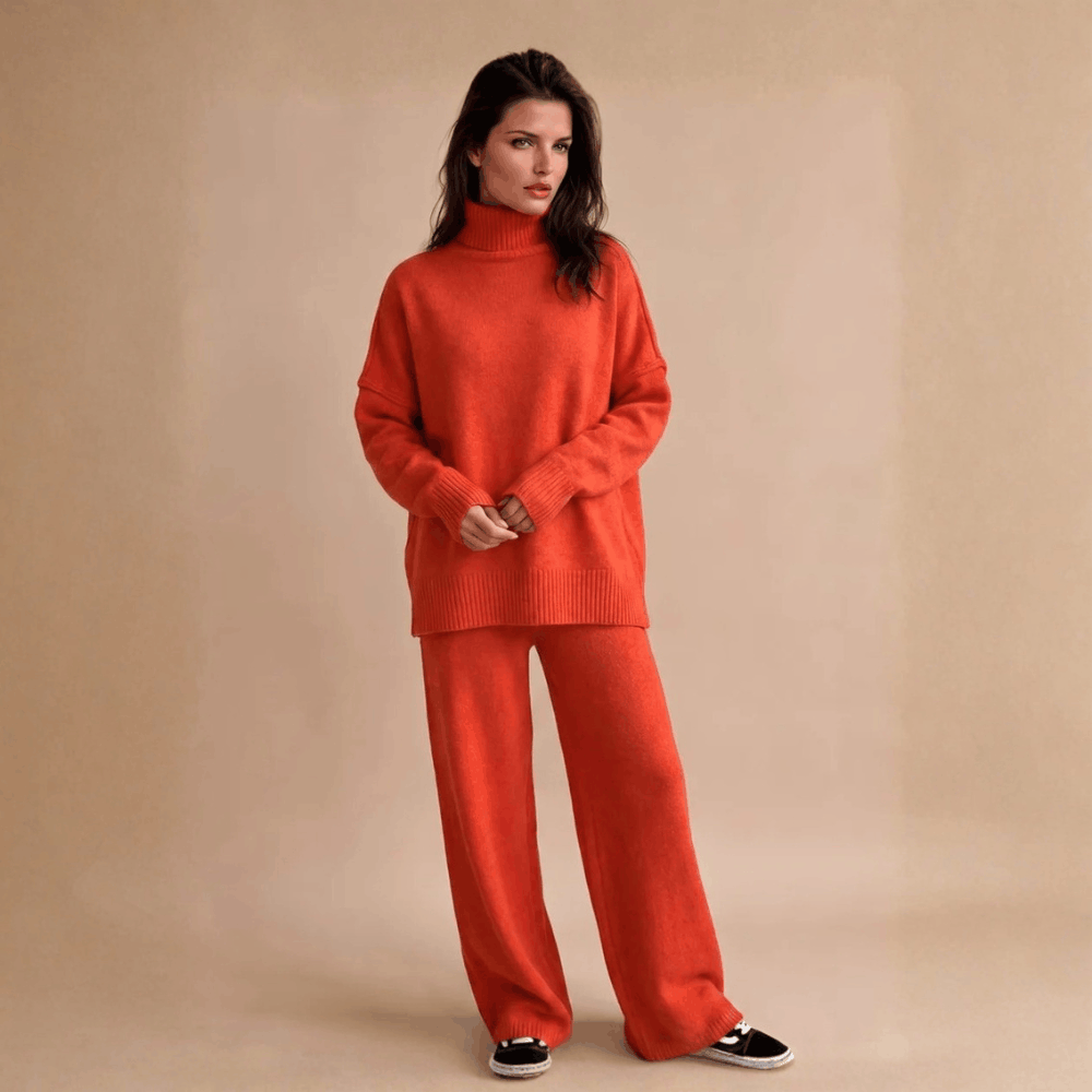 Full-length front view of a model wearing the oversized turtleneck ribbed knit lounge set in vibrant burnt orange.