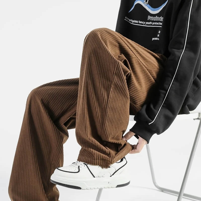 Brown corduroy pants shown in a seated pose with relaxed straight-leg fit