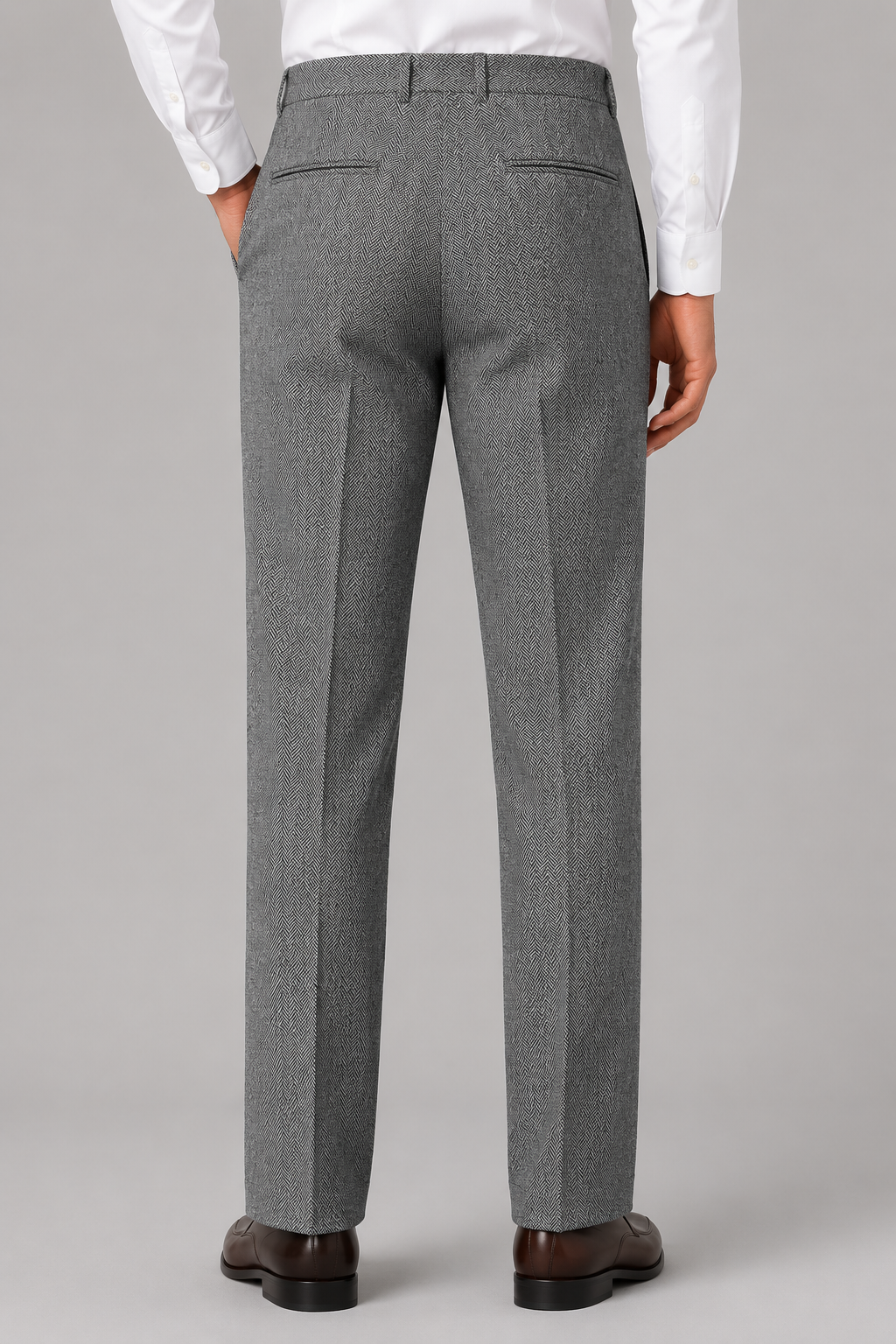 Gray herringbone trousers with a straight-leg fit, rear welt pockets, and belt loops worn with a white shirt.
