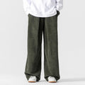 Olive green wide-leg corduroy pants featuring deep front pleats, a relaxed fit, and a comfortable drawstring waist.