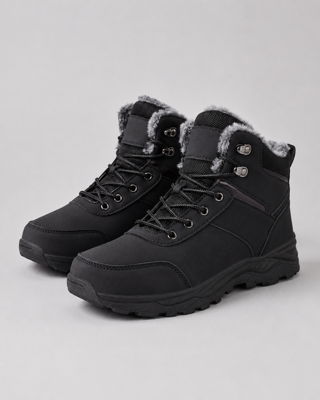 Black ankle boots with plush-lined collars, rugged lug soles, and metal lace-up speed hooks on a neutral background.