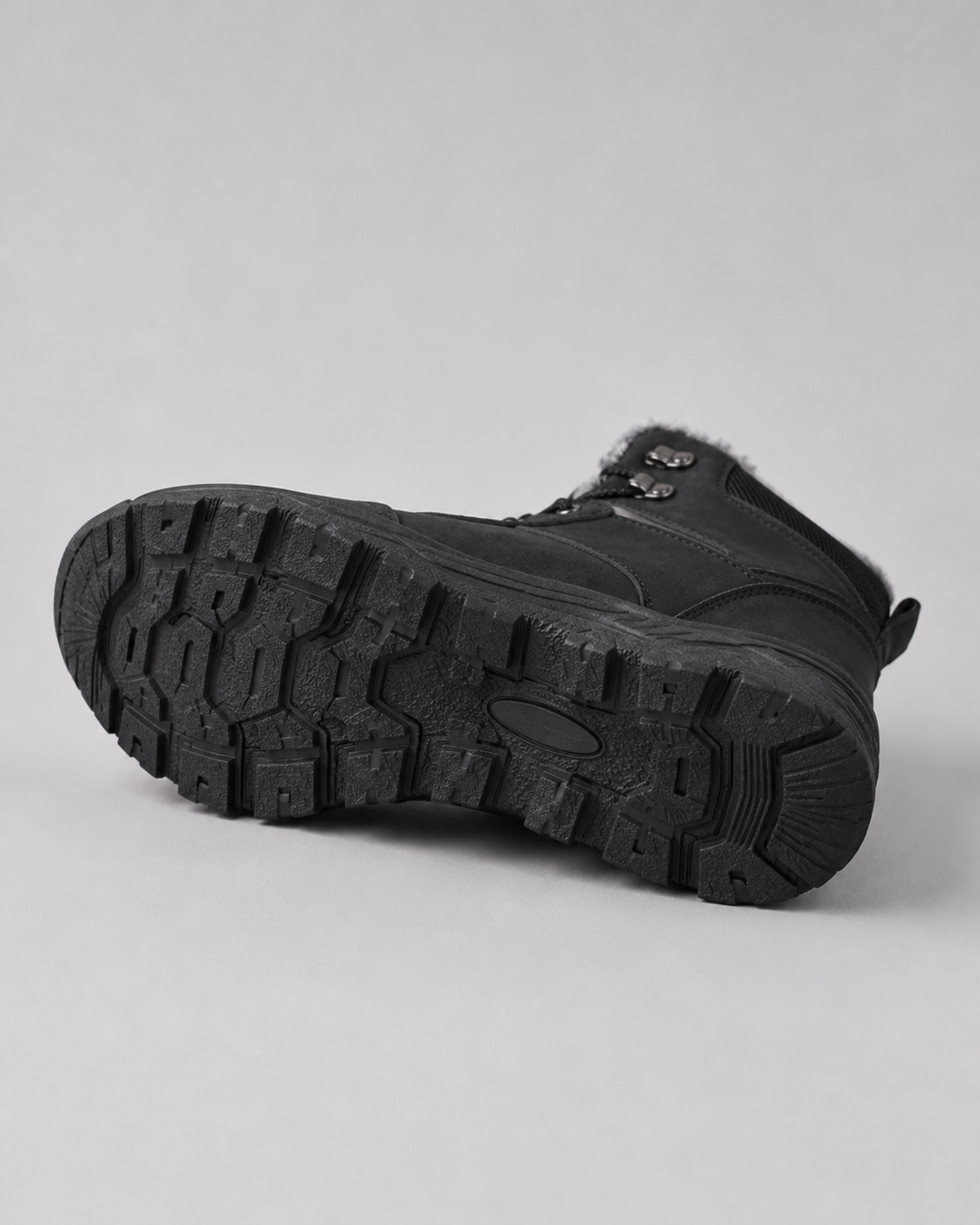 Black ankle boots featuring a rugged lug sole, plush-lined collar, and metal speed hooks on a neutral background.