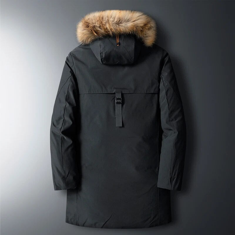 Black utility parka with a detachable plush-trim hood, longline silhouette, and rear buckle detail on a grey background.