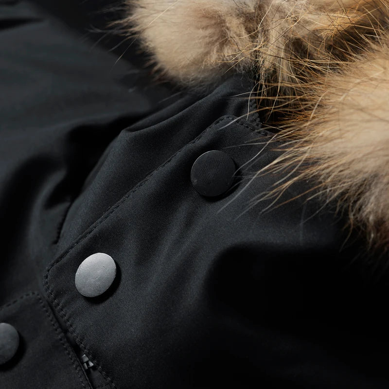 Black utility parka featuring a matte fabric, snap-button placket, and a detachable hood with plush faux-fur trim.