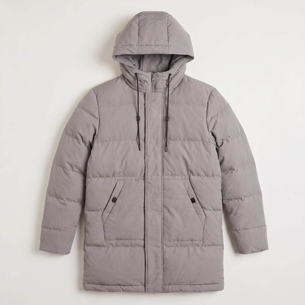 Gray longline quilted parka with horizontal padding, drawstring hood, and a concealed zip placket on a neutral background.