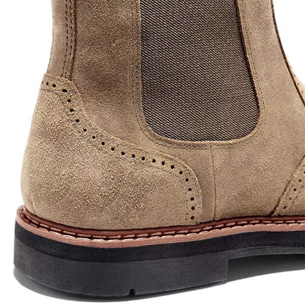 Close-up of the tan suede boot heel, showing the stitched construction and rugged rubber sole.
