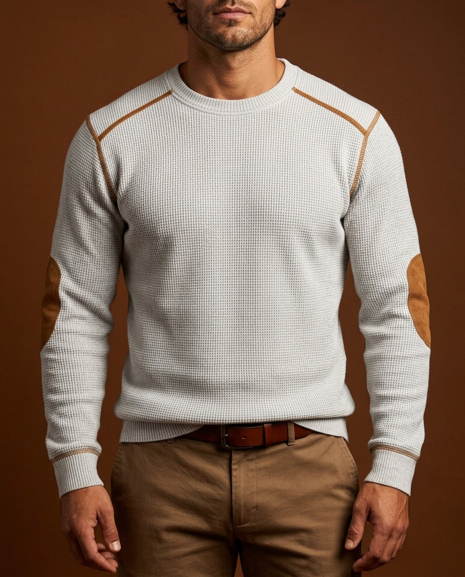 White textured crew neck knit sweater with contrast shoulder trim, long sleeves, and ribbed cuffs, styled with brown trousers.