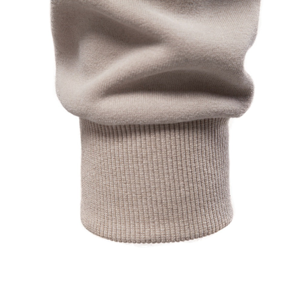 Close-up of the beige sweatshirt sleeve showing the ribbed cuff detail.