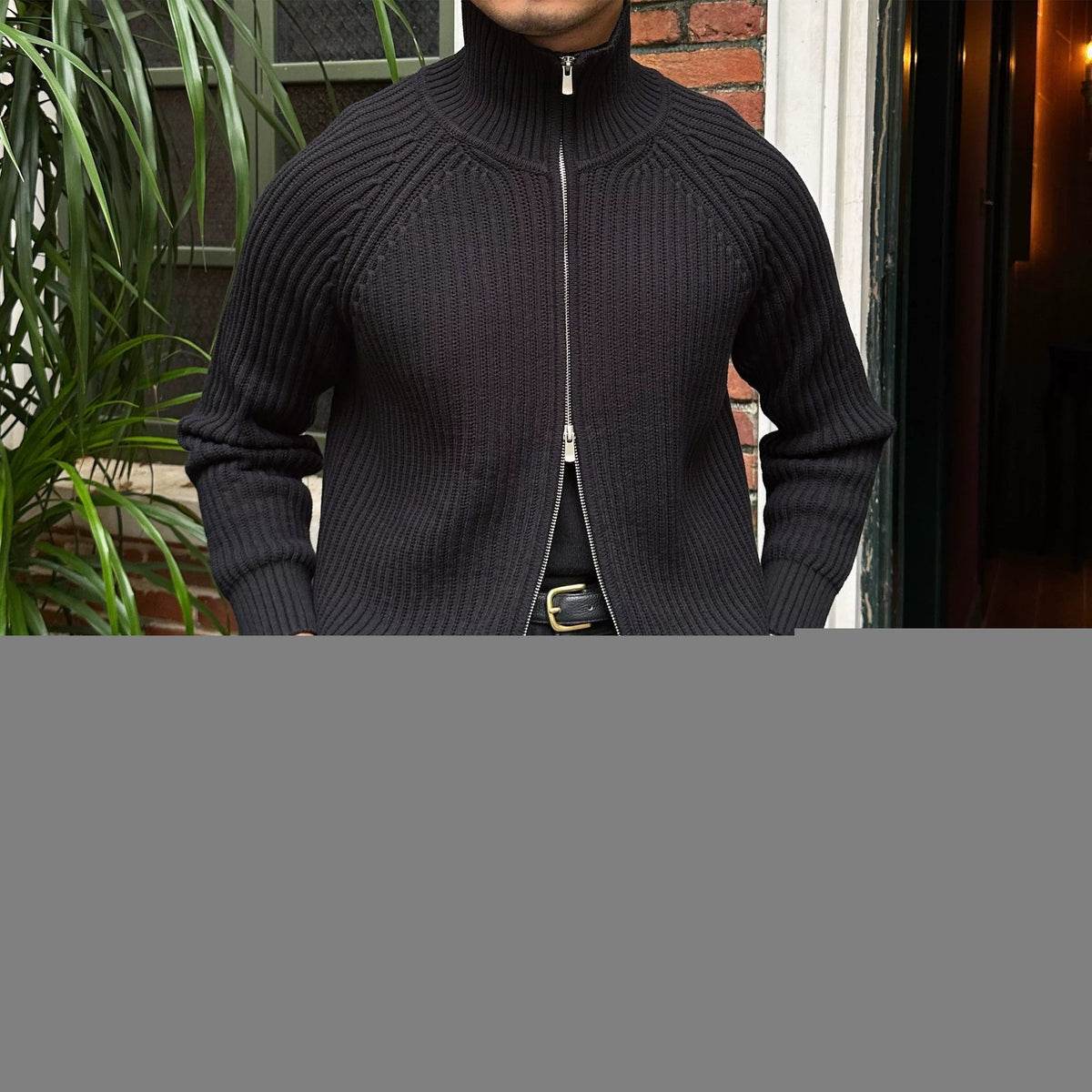 Black relaxed-fit knit cardigan in linen-blend yarn with a full-zip front, ribbed high neck, and structured cuffs.