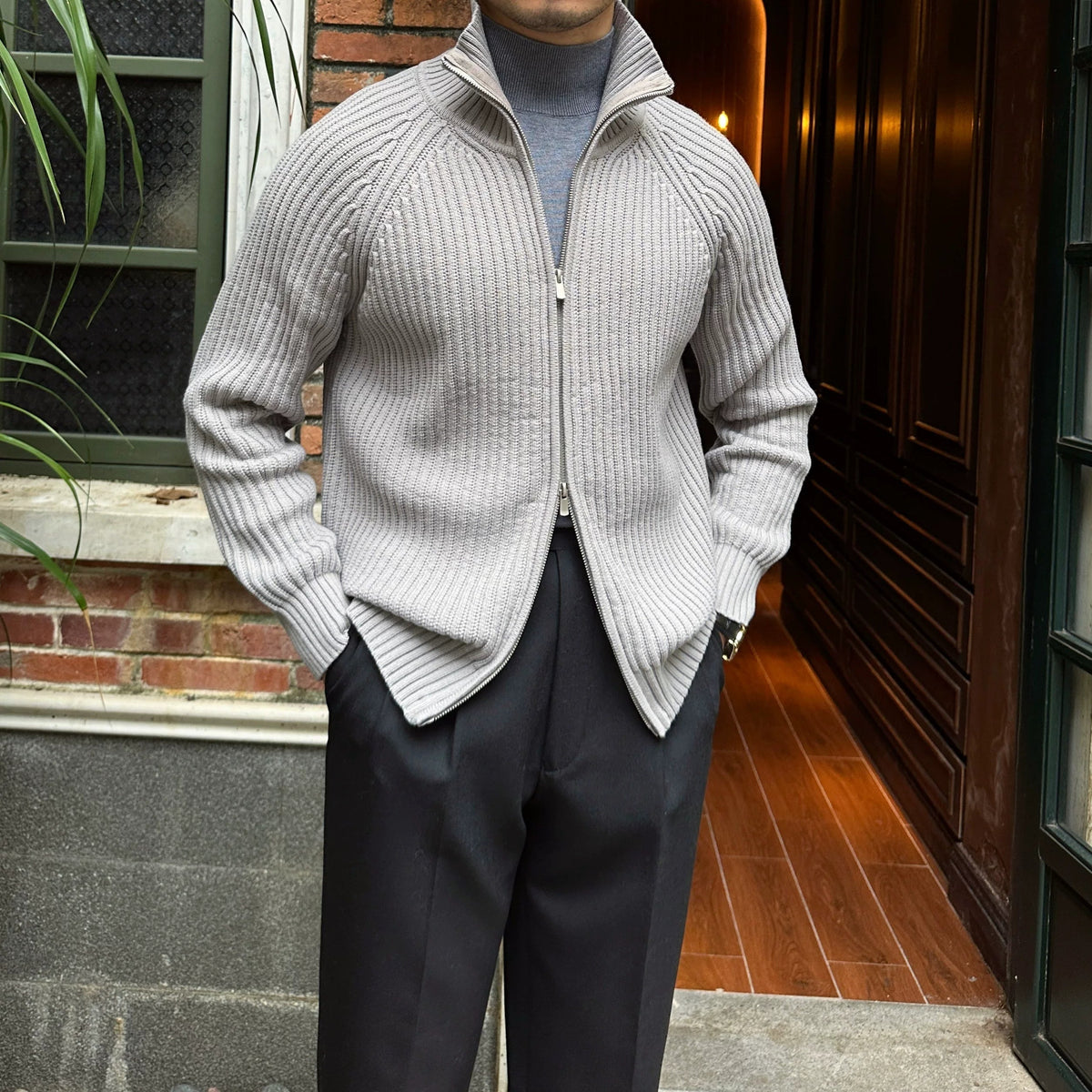Light gray linen-blend knit cardigan with a full-zip front, ribbed texture, and relaxed fit layered over a turtleneck.
