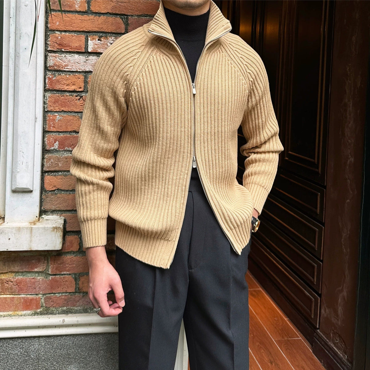 Beige linen-blend zip-up cardigan with ribbed texture, high collar, and relaxed fit layered over a black turtleneck.