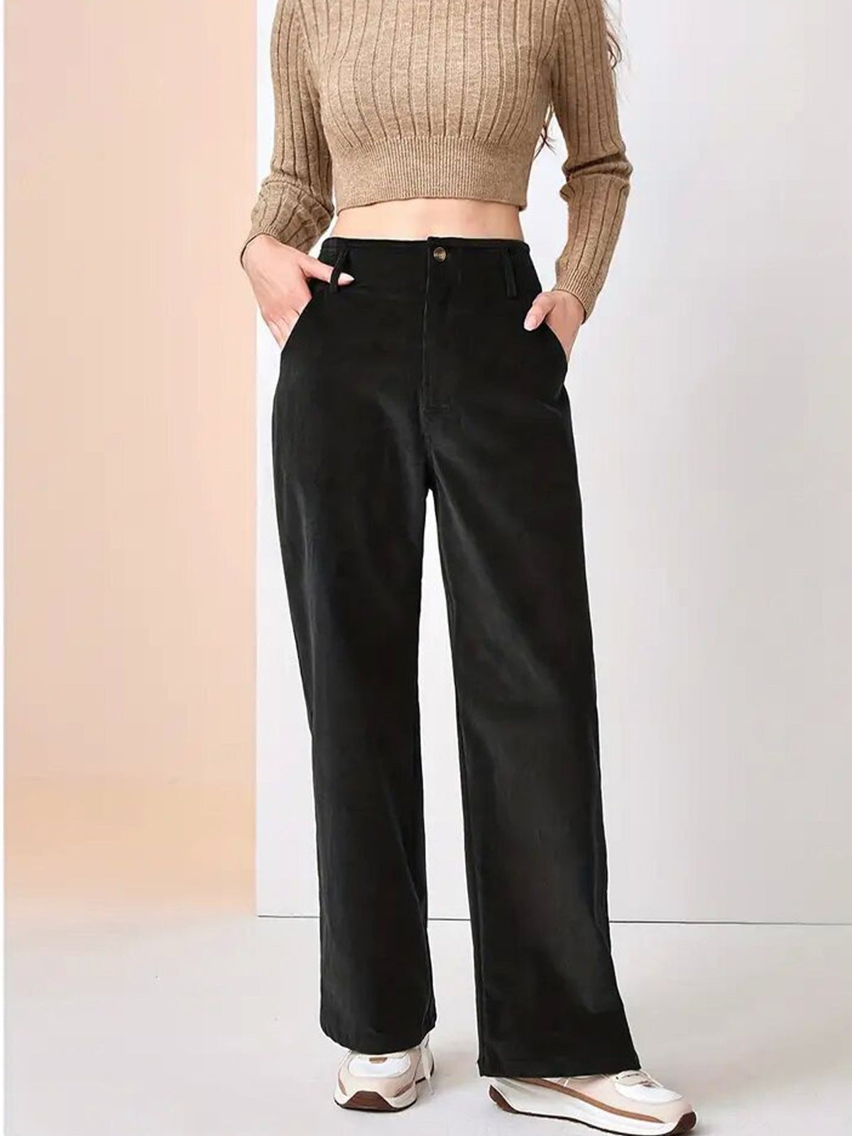 Black wide-leg corduroy pants with slant pockets, button-zip fly, and a relaxed fit paired with a cropped knit sweater.