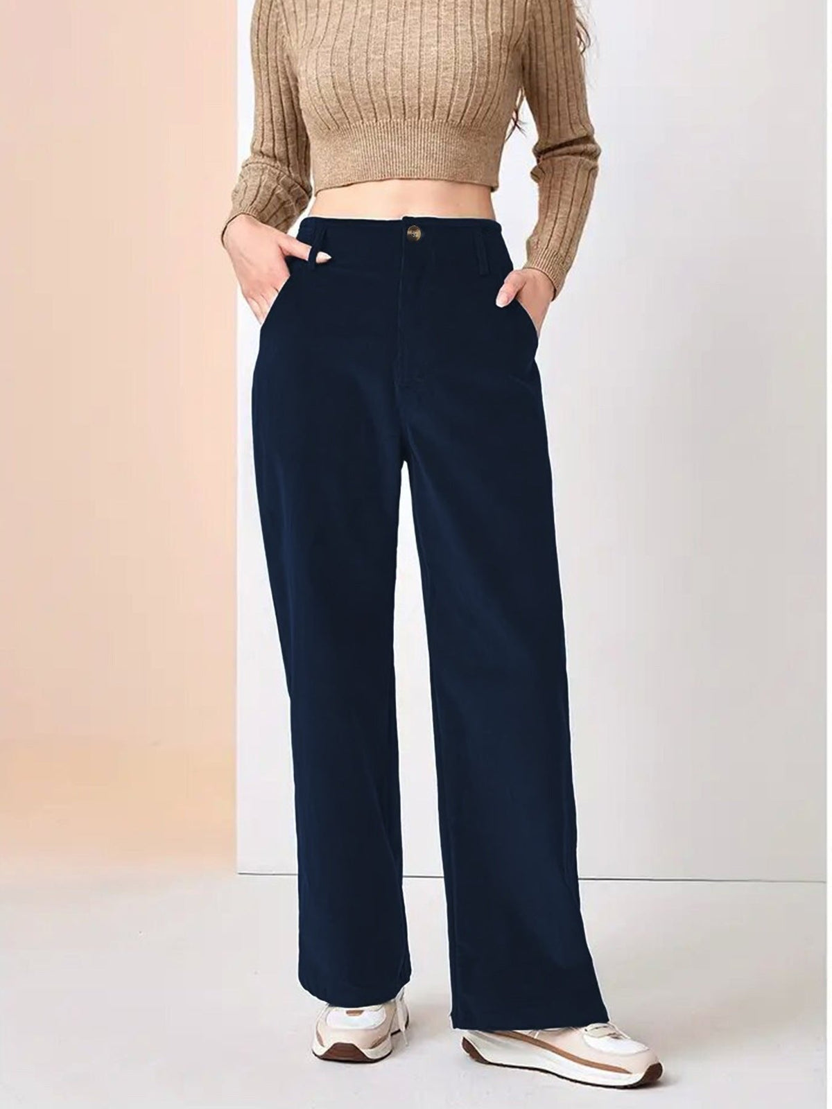 Navy blue wide-leg corduroy pants with a button-zip fly and slant pockets, styled with a cropped knit top and sneakers.