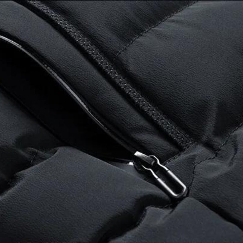 Macro close-up detail shot focusing on the smooth black zipper closure and pocket seam of the quilted puffer vest.