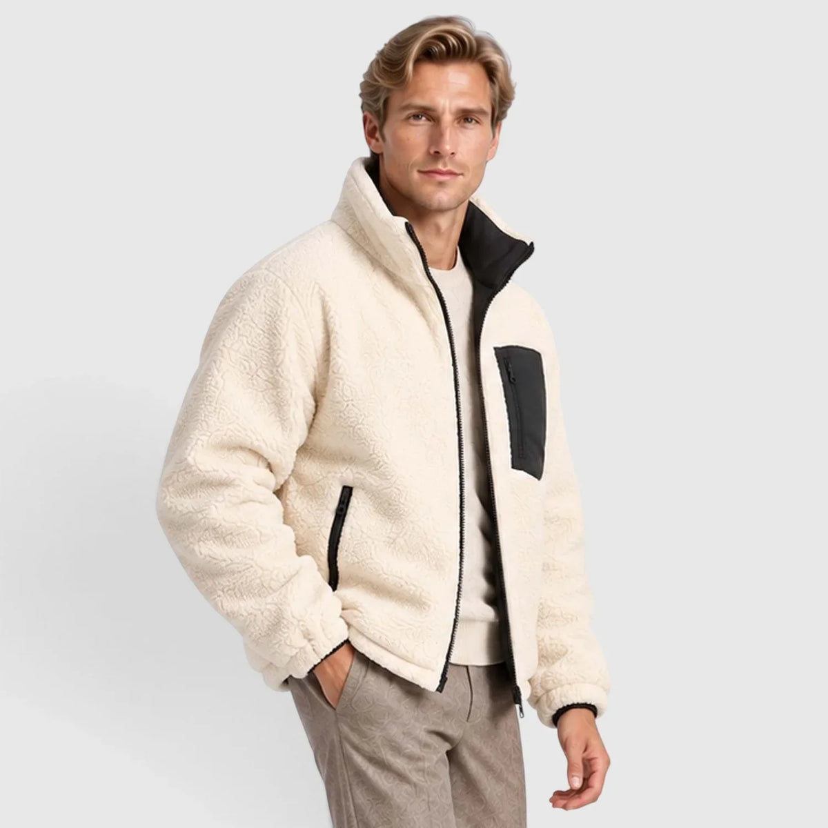 Cream-colored reversible puffer jacket with plush texture, stand collar, black zip accents, and rib-knit cuffs.