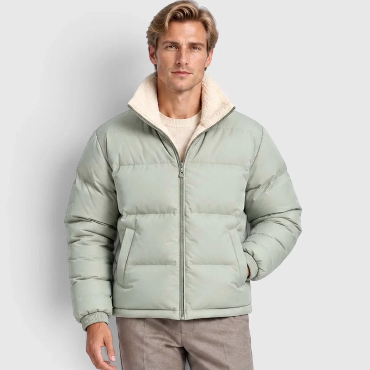 Sage green reversible puffer jacket with wide channel quilting, plush stand collar, and rib-knit cuffs on a male model.