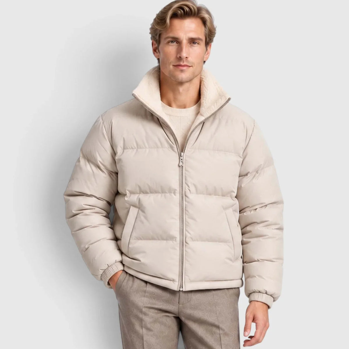 Beige reversible puffer jacket with wide channel quilting, plush stand collar, and rib-knit cuffs on a man.