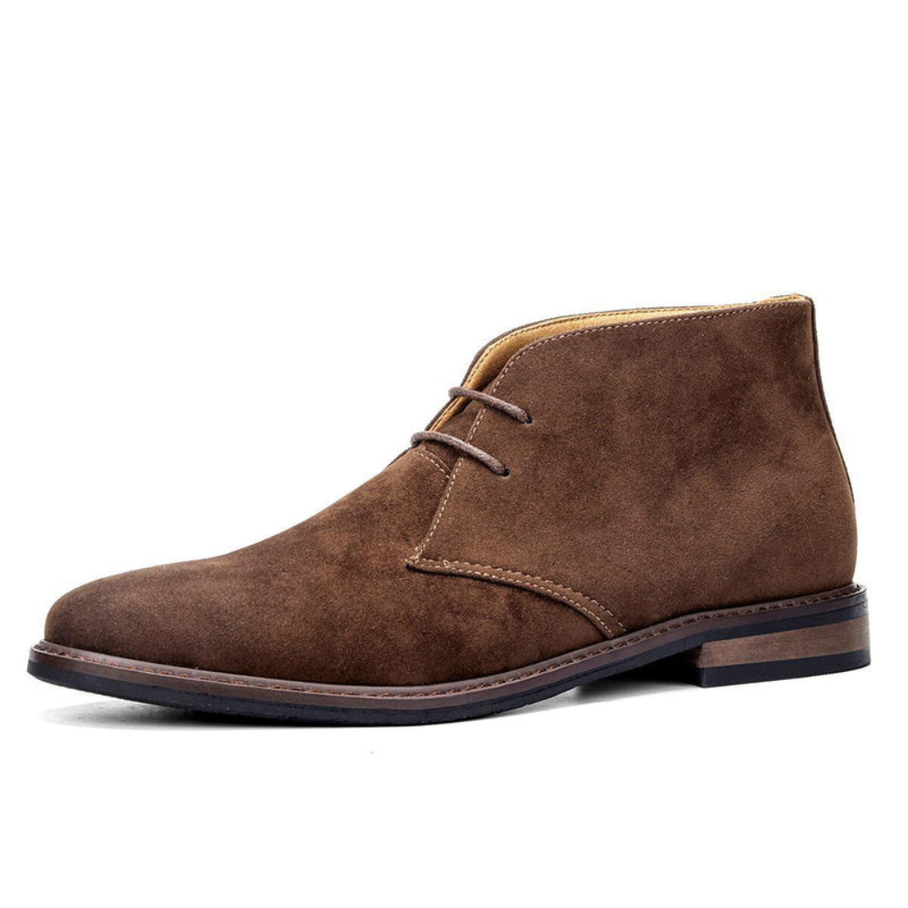 Brown suede chukka boots featuring a rounded toe, short lace-up front, and a low stacked heel with visible panel stitching.