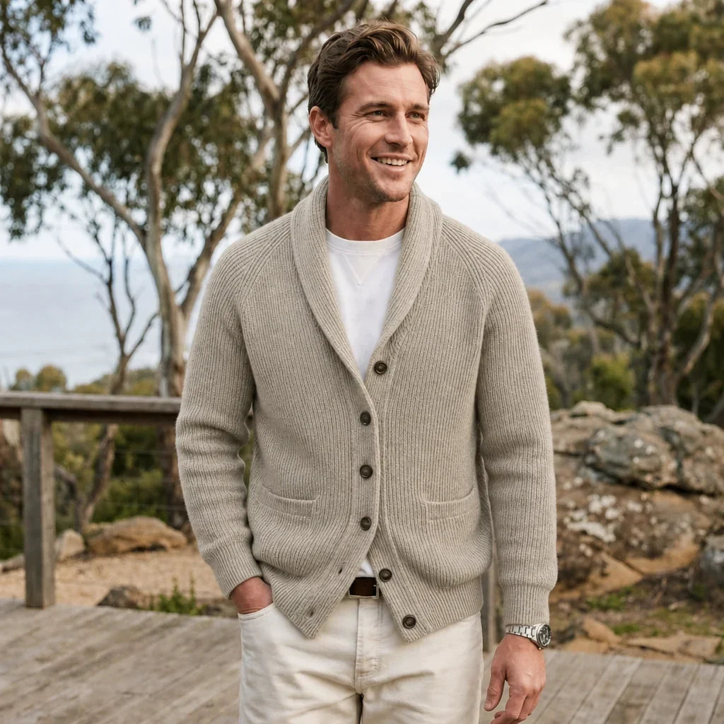 Beige ribbed knit shawl collar cardigan with raglan sleeves and front pockets worn over a white tee outdoors.