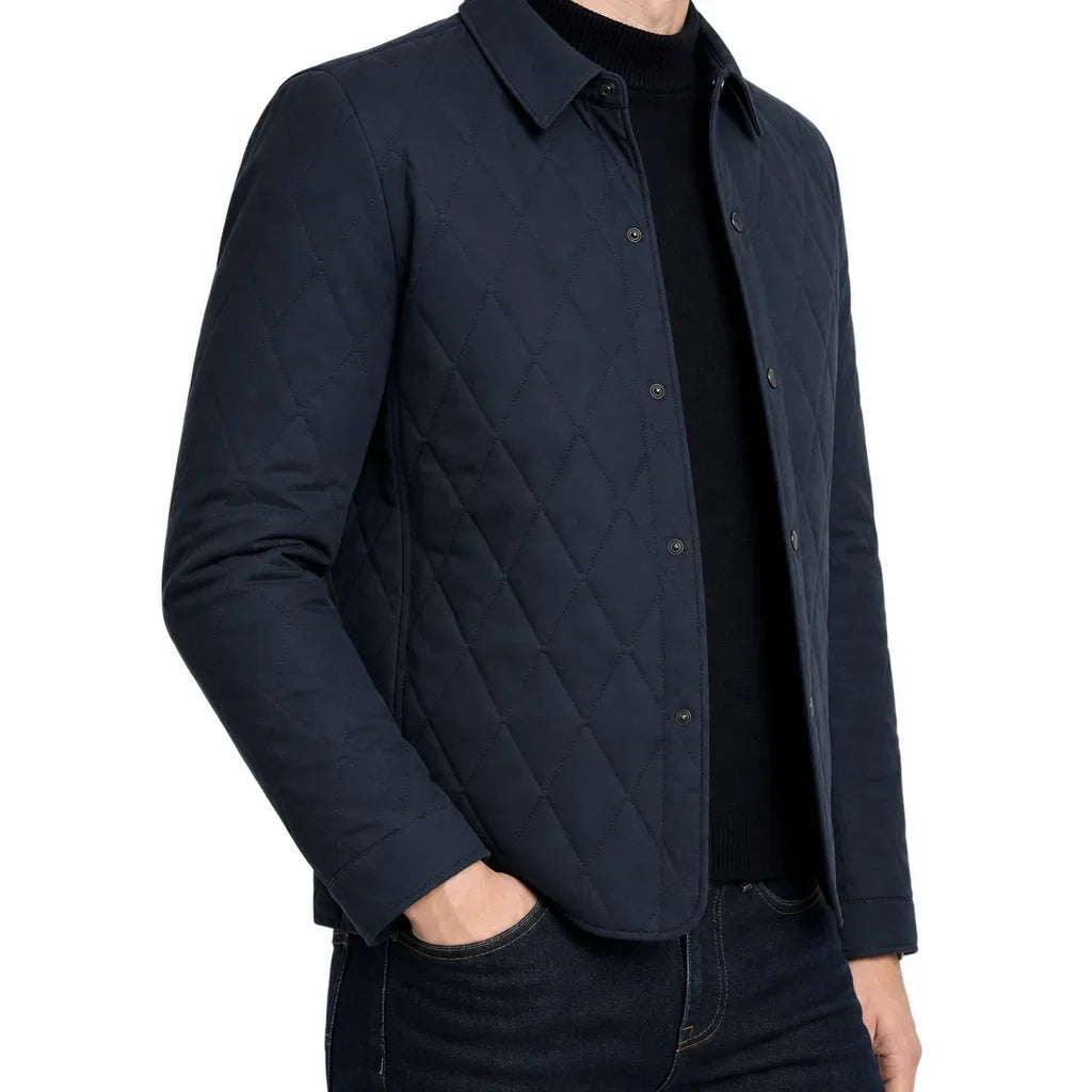 Side view of a man wearing a navy quilted button-front jacket with a classic collar and diamond quilted front.
