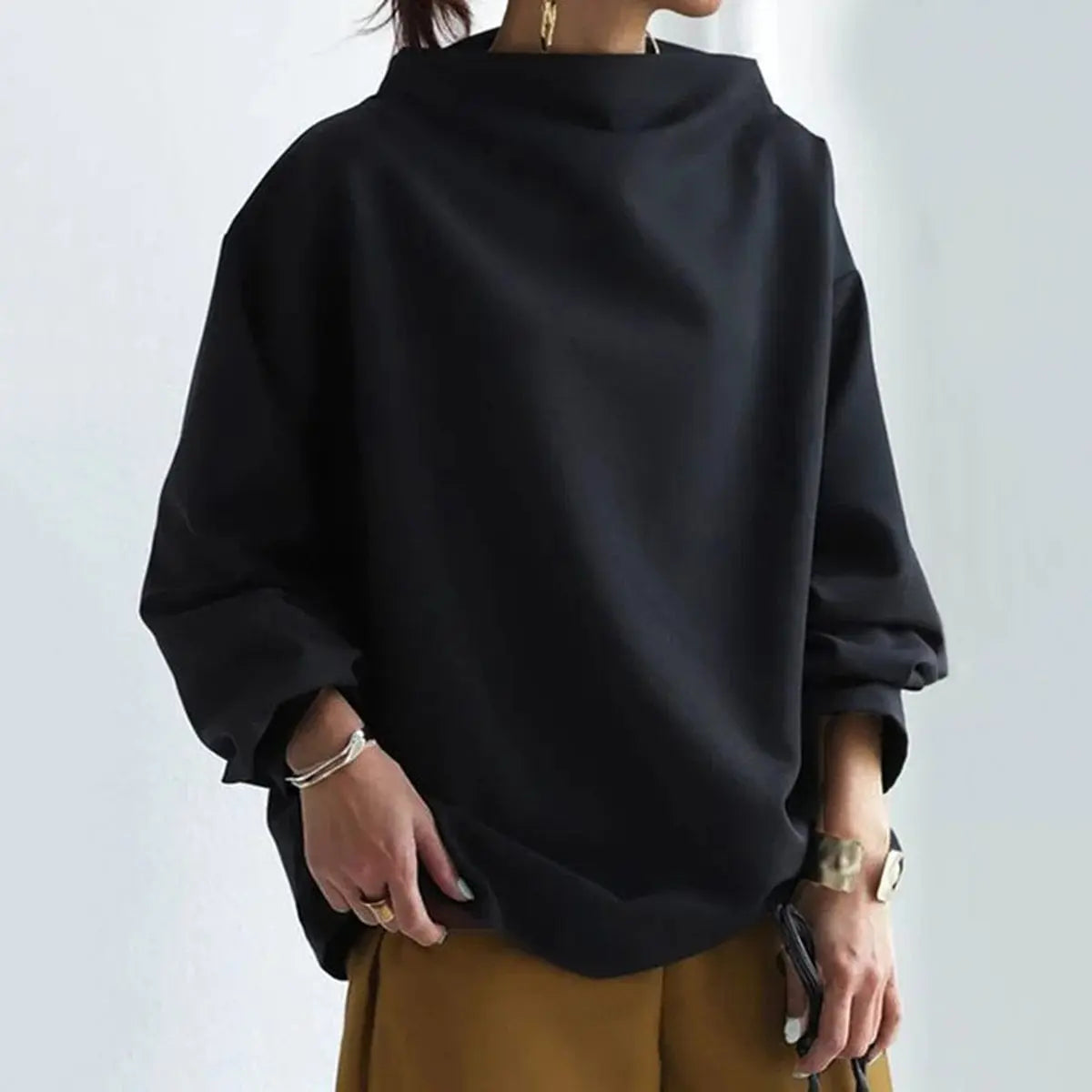 Black oversized mock neck sweatshirt with long sleeves and a relaxed fit, styled with casual accessories.