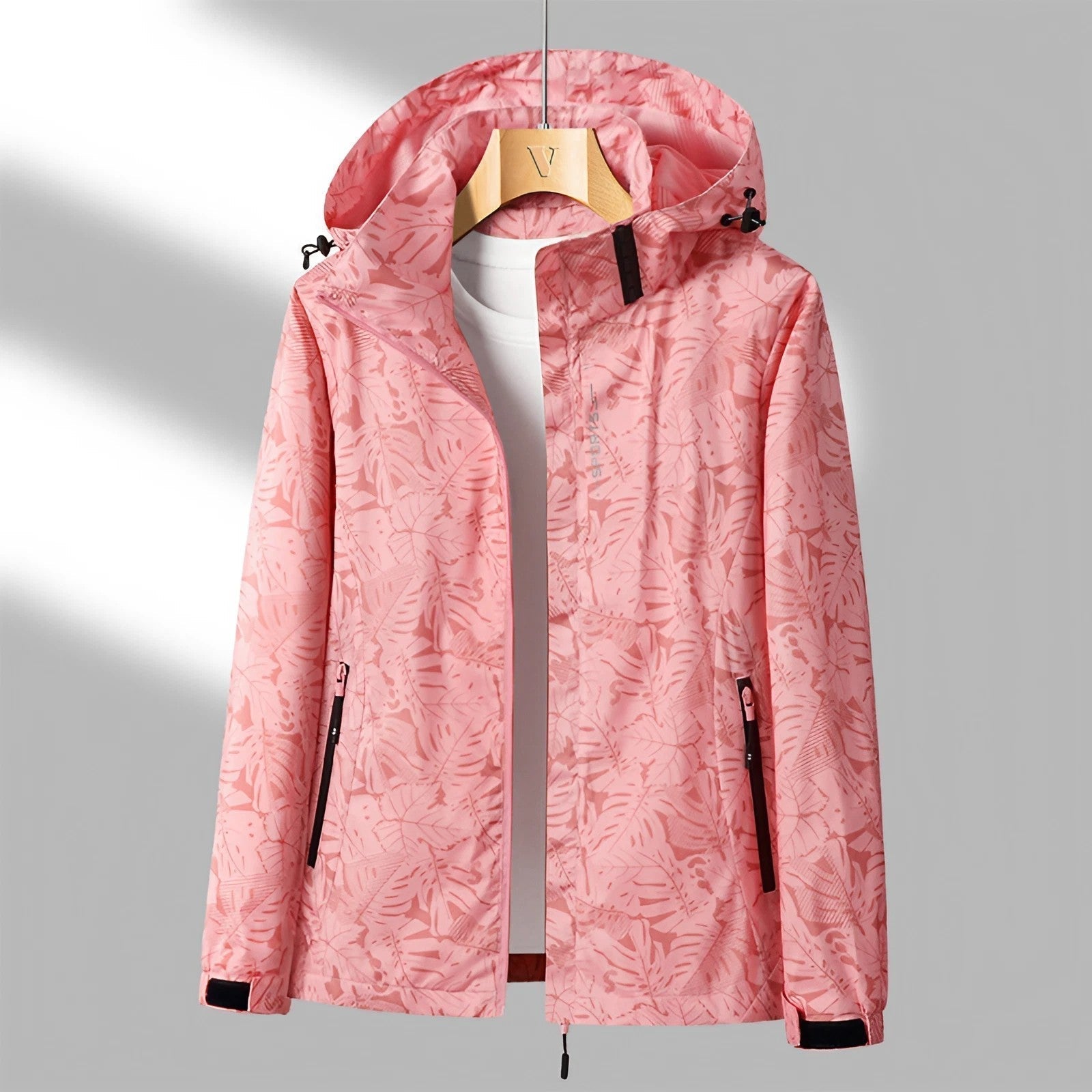 Pink hooded waterproof jacket with a full-zip front, adjustable hood, zippered pockets, and long sleeves displayed on a white background.