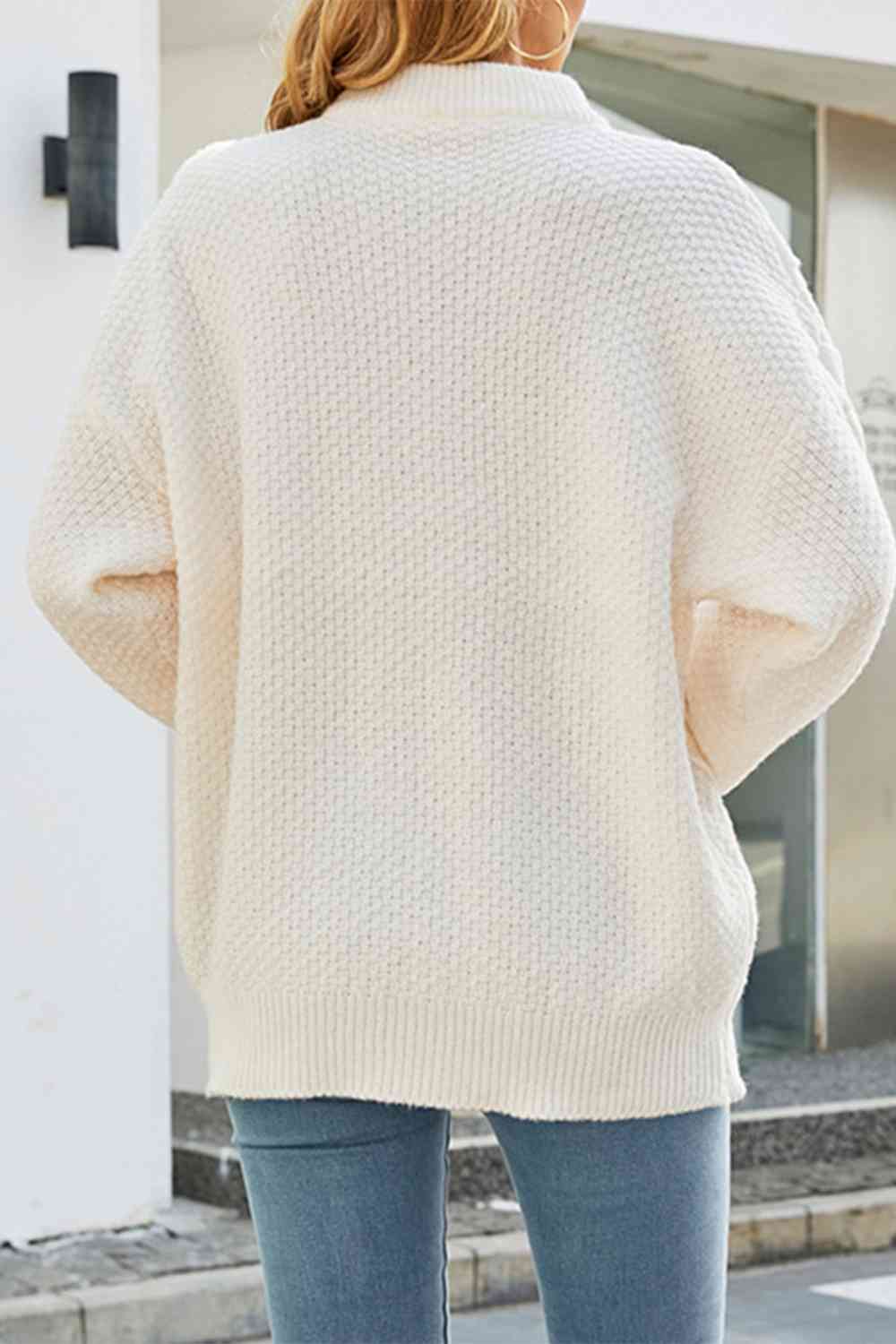 Cream oversized crewneck sweater with a textured cable-knit pattern, drop shoulders, and a relaxed, cozy fit.