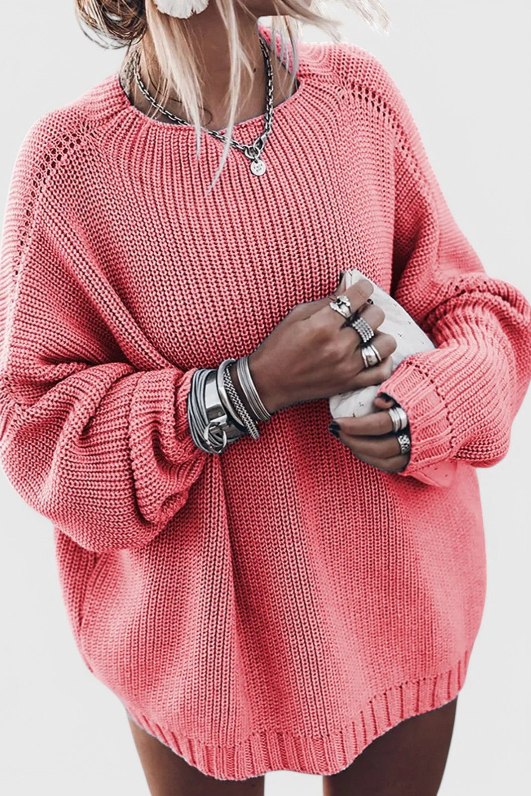 Coral pink oversized chunky knit sweater featuring a ribbed crew neckline, textured knit pattern, and balloon sleeves for a cozy everyday style.