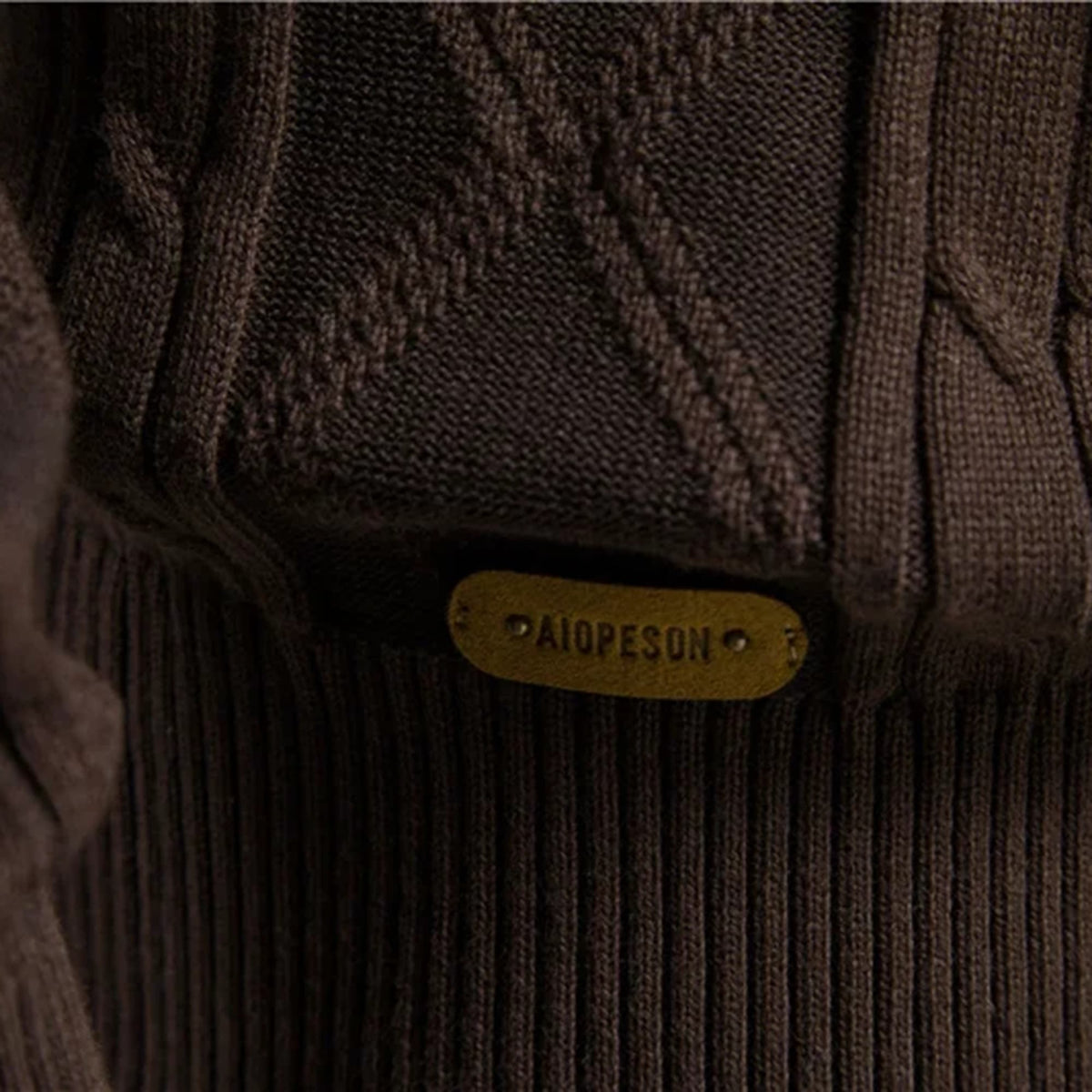 Dark brown stretch cotton cardigan featuring a textured diamond and cable knit pattern with a ribbed hem.