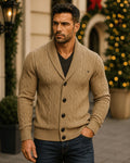 Tan cable knit cardigan with a shawl collar, diamond texture, and button-front closure worn over a dark v-neck shirt.