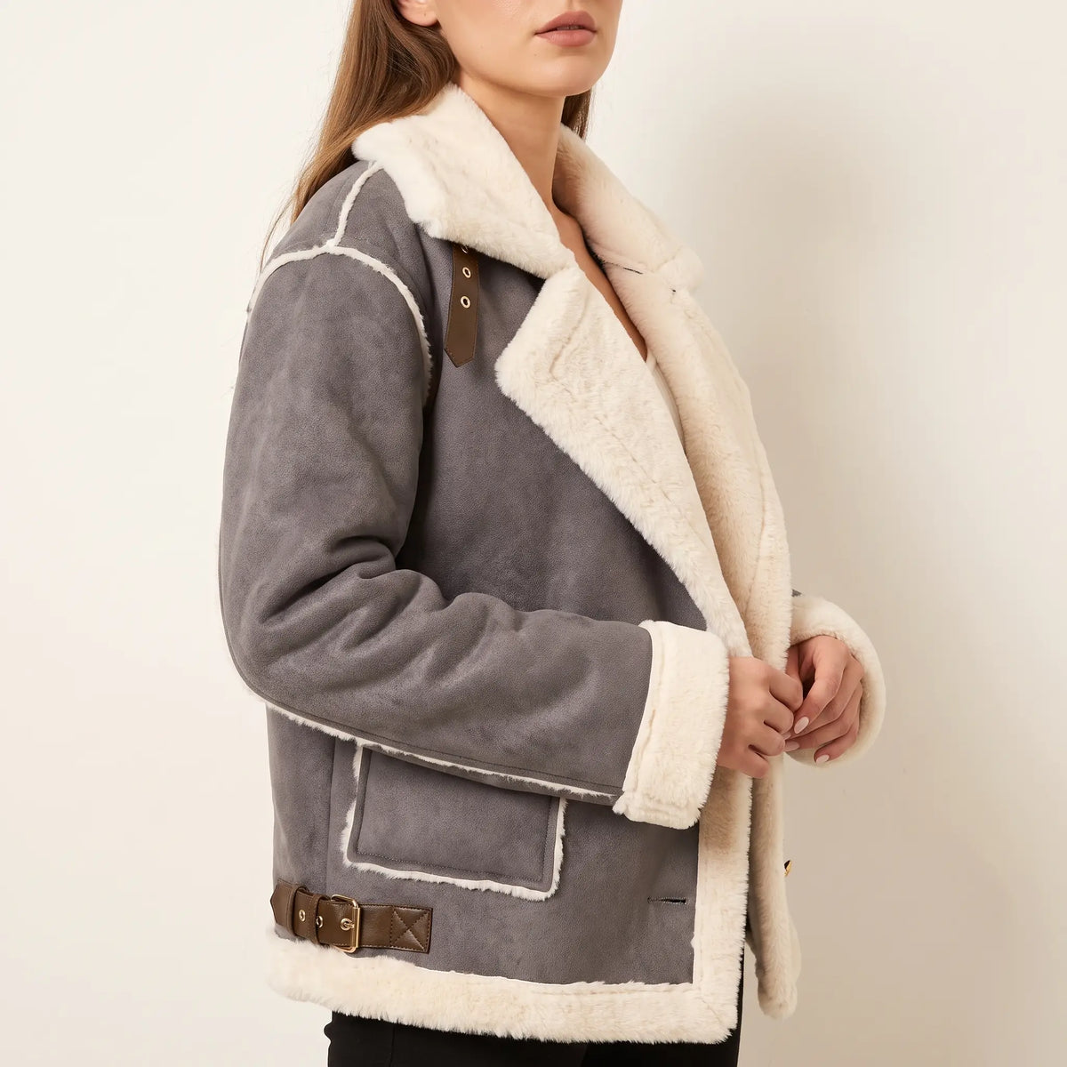 Gray shearling aviator jacket with a plush cream collar, buckle shoulder straps, and trimmed cuffs in a relaxed fit.