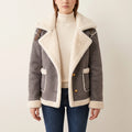 Gray shearling aviator jacket with a wide cream lapel, buckle shoulder straps, and button-front closure.