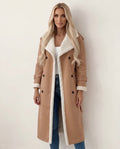 Tan longline shearling coat with a double-breasted front, wide cream-colored collar, and plush textured trim.