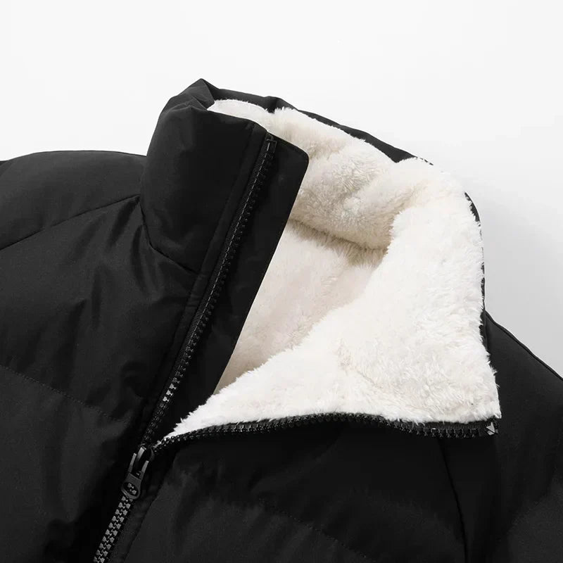Black quilted puffer jacket featuring a high mock neck and plush cream sherpa lining with a full-zip front closure.