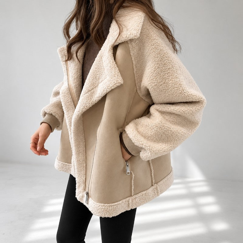 A woman wearing a cream sherpa suede aviator jacket with an oversized lapel and zip front, shown in side view
