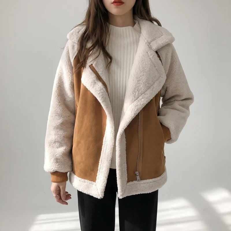 A woman wearing a brown sherpa suede aviator jacket with an oversized lapel and zip front